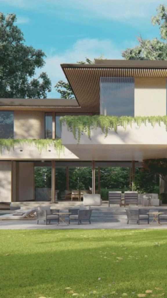 An ultra-modern luxury bungalow boasting a stunning two-story architectural design that seamlessly blends indoor and outdoor spaces. The home features a flat roof accented with crisp vertical wooden slats underneath, large glass windows, and an expansive cantilevered upper balcony draped with lush, cascading green vines. Below, a massive open-concept covered patio serves as an outdoor living room, completely open to a perfectly manicured green grass lawn. The patio is furnished with multiple contemporary gray outdoor lounge sets, armchairs, and matching coffee tables arranged for resort-style relaxation.