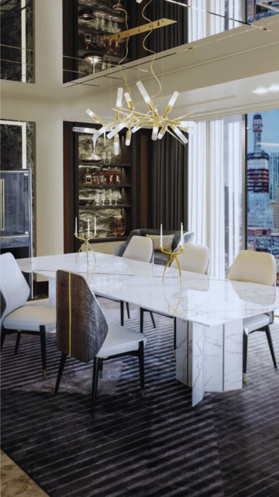 A sophisticated, moody living room corner at night. A minimalist dark wood shelf or console features a collection of elegant decor pieces, including a clear glass vase with delicate white blooms and curated hardback books. Twin contemporary wall sconces cast downward arcs of warm golden light against the dark, vertically paneled backdrop, creating deep contrast and sharp highlights.